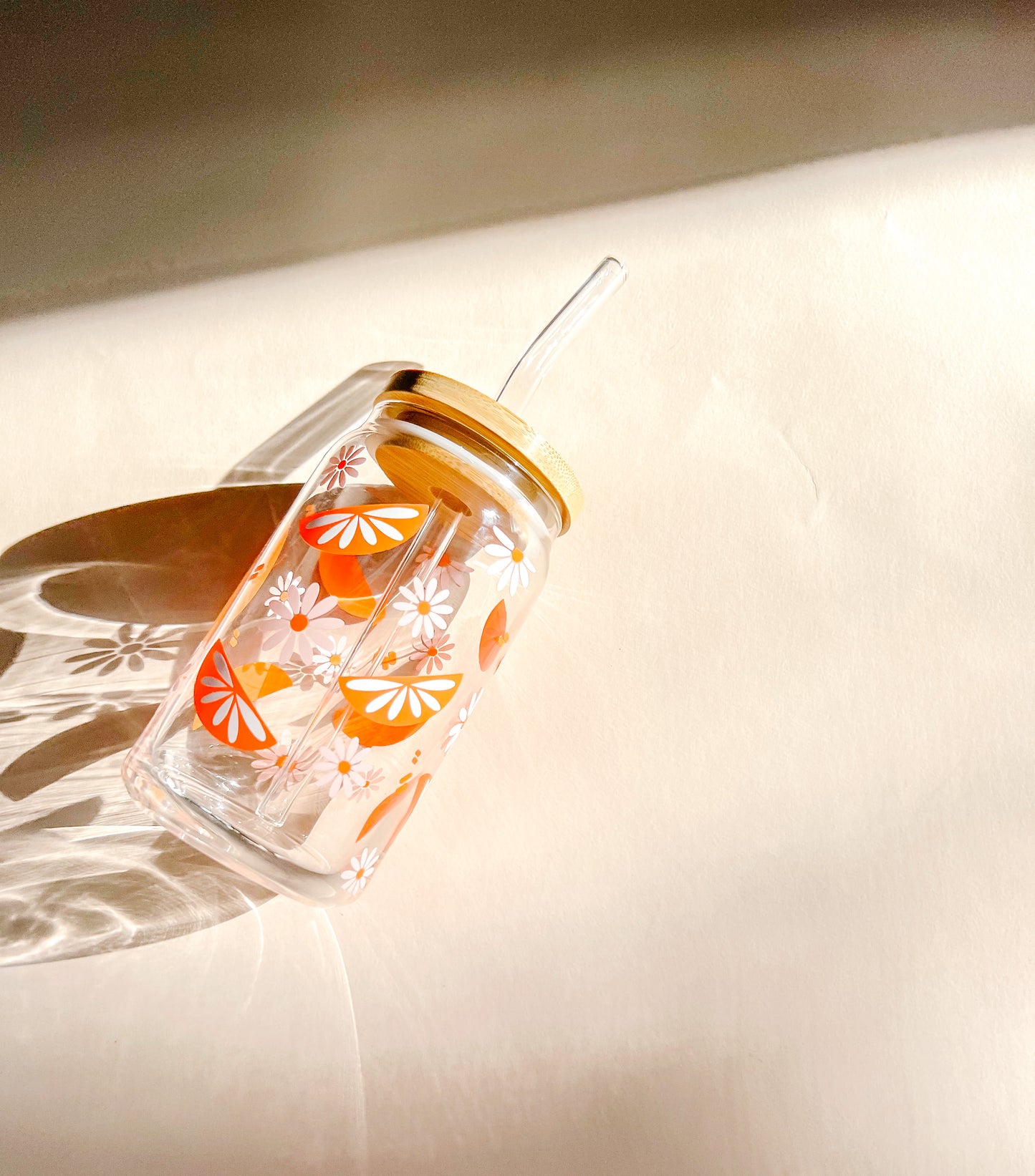glass cup with orange slices and pink daises