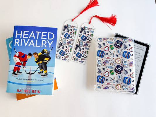 Book titled 'Heated Rivalry' by Rachel Reid with hockey-themed bookmarks and a notebook on a white background.