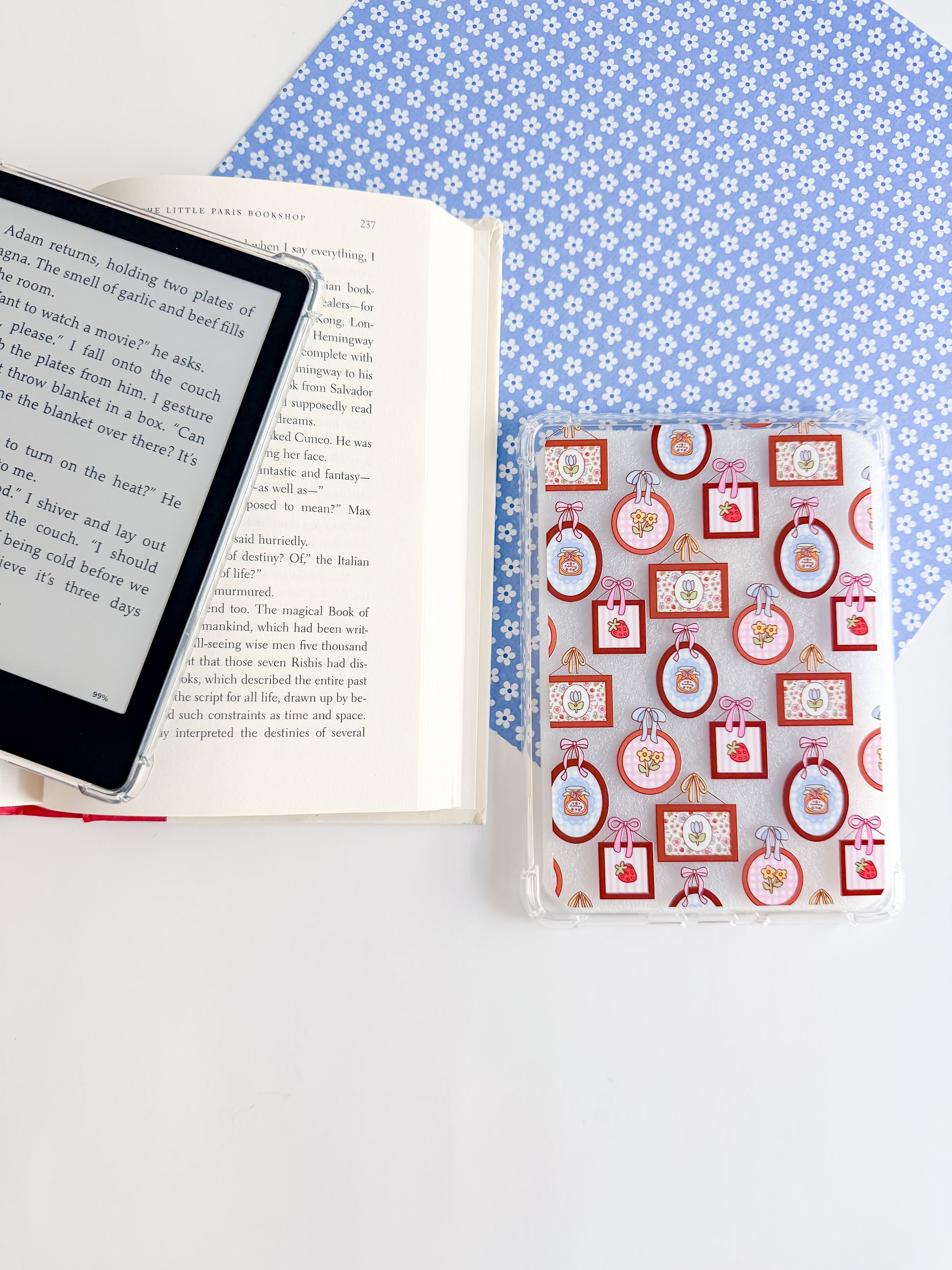 E-reader and book on a blue polka dot surface with a decorative box.
